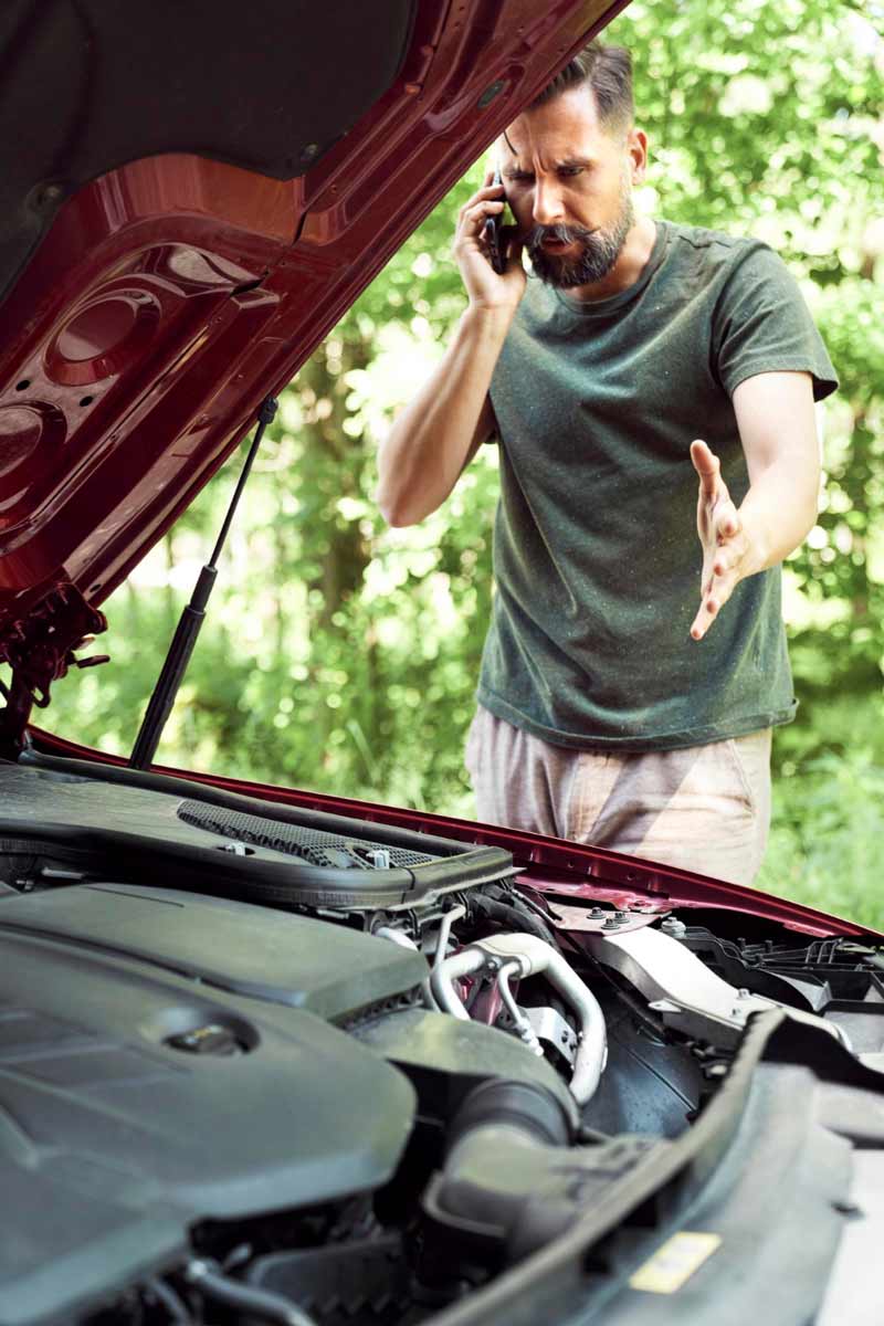Junger Mann prüft Getriebeschaden bei Schrottauto Ankauf Borken